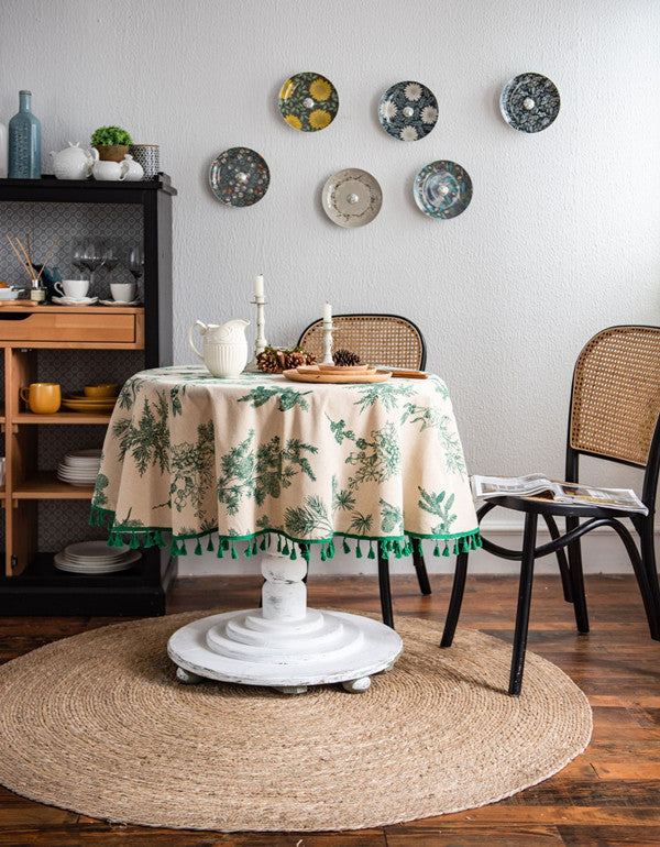 Nappe ronde à pompons avec imprimé branches de pin vert